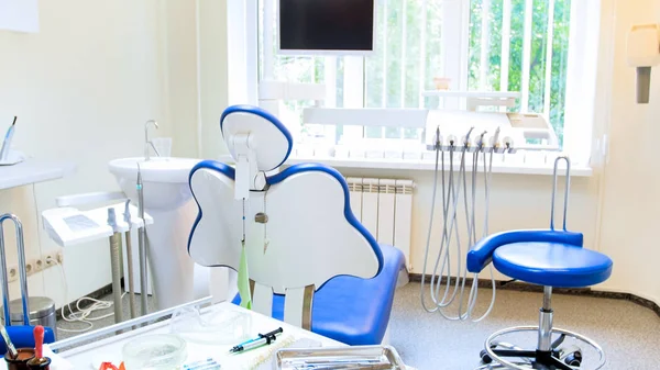 Dentist tools and chair in modern dental clinic