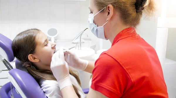 Retrato de dentista feminino examinando dentes meninas na clínica — Fotografia de Stock