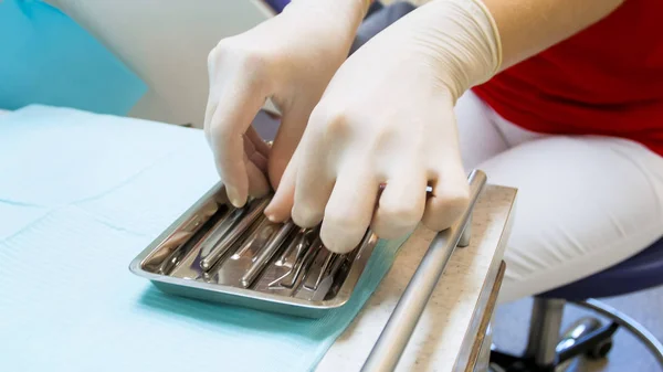 滅菌ツールを取って女性歯科医の手のクローズ アップ画像 — ストック写真