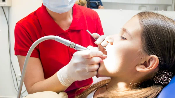 Close-up foto van pediatrische tandarts behandeling van meisjes tanden met boor — Stockfoto