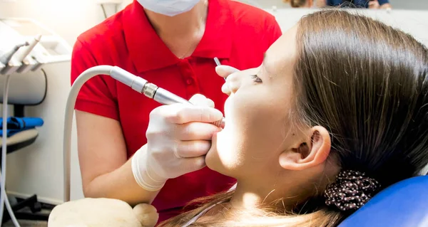 Imagem de close-up do dentista pediátrico usando broca dentária durante o tratamento de dentes girrls — Fotografia de Stock