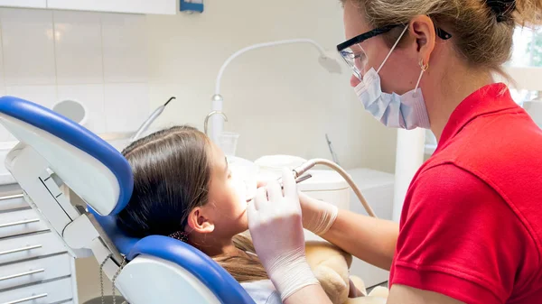 Portret zbliżenie dentysta, leczenie zębów nastoletnich dziewcząt z wiertła — Zdjęcie stockowe