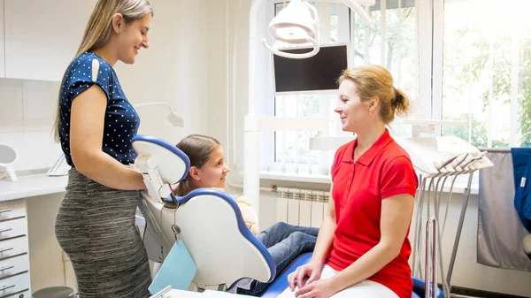 Jovem mãe com filha visitando consultório de dentista para check-up — Fotografia de Stock