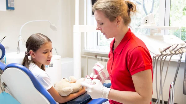 Női gyermekorvosi fogorvos mutatja a mesterséges állcsont ő beteg — Stock Fotó
