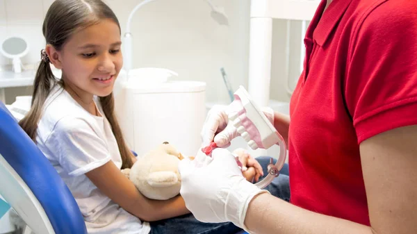 Közelkép kép a gyermekorvosi fogorvos, állkapocs modell segítségével megmutatni, hogyan-hoz illően tiszta a fogak — Stock Fotó