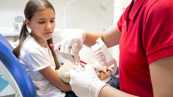 Imagem de perto do dentista pediátrico explicando como limpar adequadamente os dentes para seu paciente — Fotografia de Stock