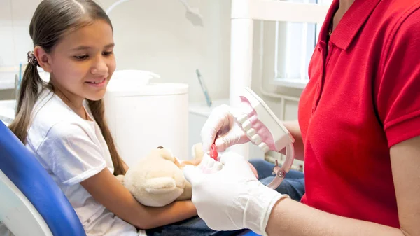 Imagem de close-up do dentista pediátrico explicando como limpar os dentes no modelo de mandíbula — Fotografia de Stock