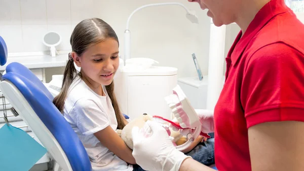 Dentista pediátrico mostrando como usar escova de dentes para seu pequeno paciente — Fotografia de Stock