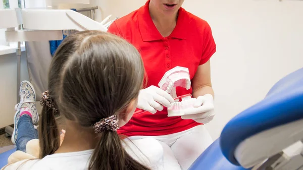 Zbliżenie obrazu dziewczynka słuchania o higienę zębów w gabinecie stomatologicznym — Zdjęcie stockowe