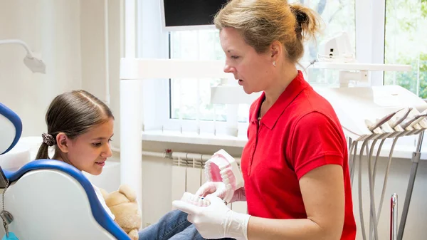 Retrato de dentista feminina conversando com seu paciente sobre higiene dos dentes — Fotografia de Stock