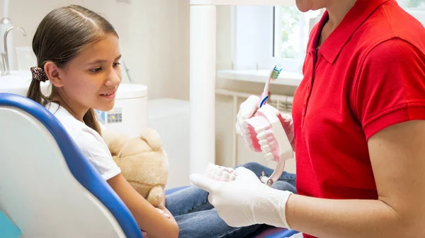 Close-up imagem de menina bonito ouvir sobre a limpeza dos dentes no consultório odontológico — Fotografia de Stock