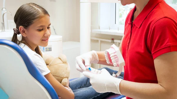 Immagine di primo piano del dentista pediatrico utilizzando il modello di plastica per educare come pulire correttamente i denti — Foto Stock