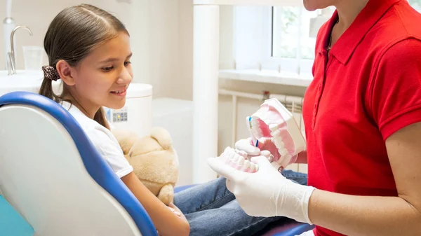 Närbild bild av tandläkare undervisning lilla flicka rengöring tänderna — Stockfoto