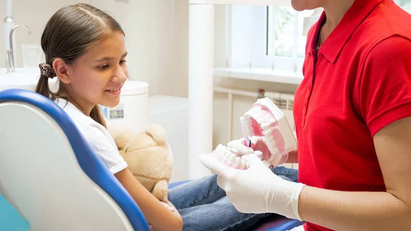 Imagem de perto do dentista pediátrico usando modelo de mandíbula plástica para educar o paciente — Fotografia de Stock