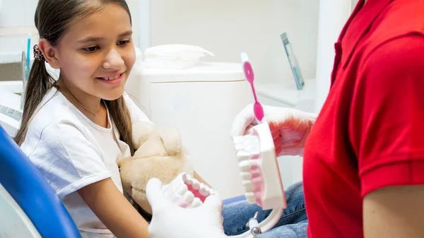 Imagem de perto do dentista pediátrico explicando a importância da limpeza adequada dos dentes — Fotografia de Stock