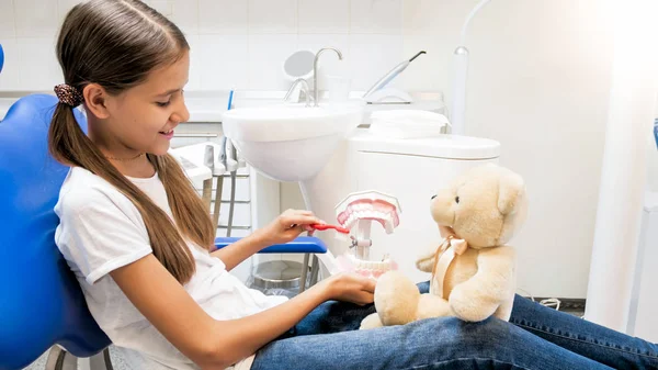 Aranyos mosolygós lány ül a fogorvos szék, és játszik a mackó — Stock Fotó