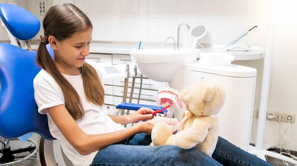 Retrato de menina com ursinho brincando no consultório odontológico na clínica — Fotografia de Stock