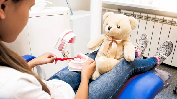 Foto close-up de menina educando seu ursinho de pelúcia como limpar adequadamente os dentes — Fotografia de Stock