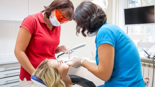 Dentista e assistente de limpeza dos dentes dos pacientes antes do tratamento — Fotografia de Stock