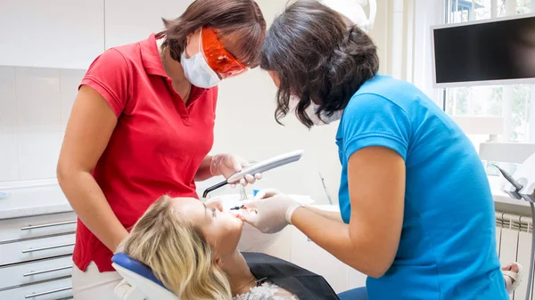 Portret van tandarts en assistent behandelen patiënten tanden — Stockfoto