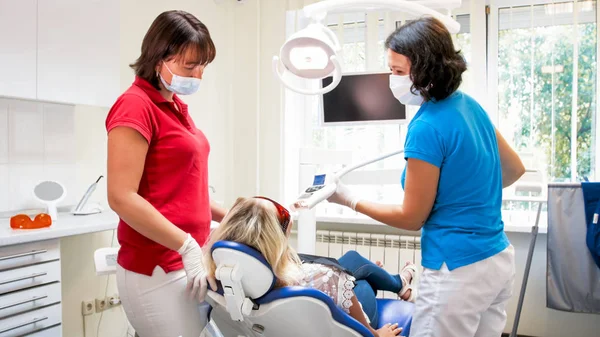 Dentista ajustando lâmpada UV especial para clareamento dos dentes — Fotografia de Stock