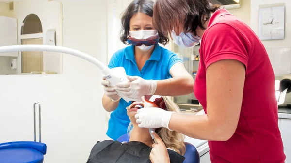 Dentista docente ajustando lâmpada UV para o procedimento de clareamento dos dentes — Fotografia de Stock
