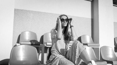 Siyah beyaz portre Stadı emty koltukta oturma genç şık kadın