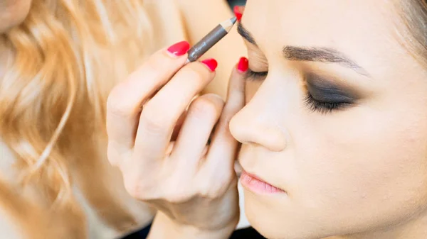 Closeup image of makeup artist painting models eyebrows with contouring pencil — Stock Photo, Image