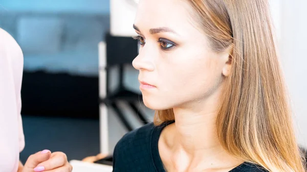 Retrato de cerca de una joven rubia sentada en una silla en el salón de belleza — Foto de Stock