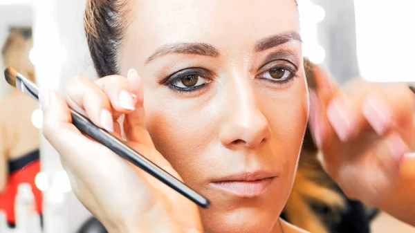 Closeup image of makeup artist hands touching models face — Stock Photo, Image