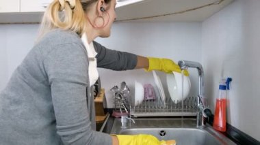 mutlu genç ev hanımı müzik dinleme ve bulaşıkları yıkarken şarkı 4 k görüntüleri