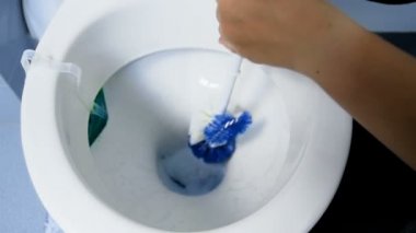 Genç kadın çamaşır deterjan ve fırça ile kirli tuvalet closeup ağır çekim görüntüleri