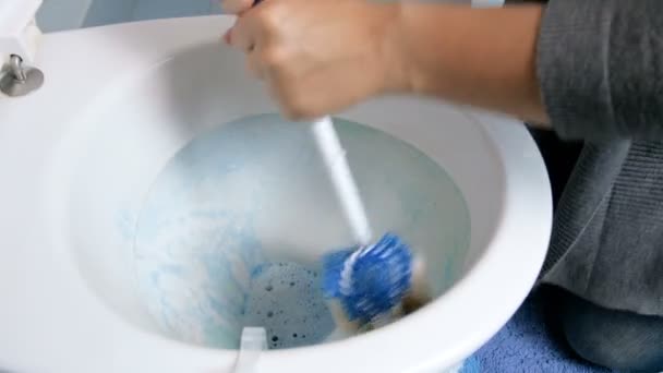 Крупный план 4k кадров, где молодая домохозяйка чистит грязный туалет щеткой и моющим средством — стоковое видео