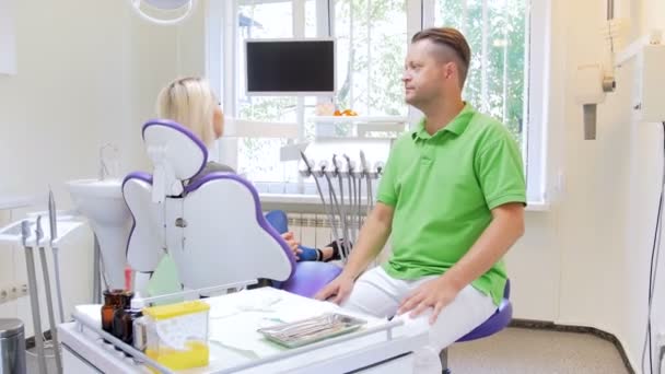 4k steadycam video de dentista poniéndose máscara quirúrgica y hablando con paciente femenino — Vídeo de stock