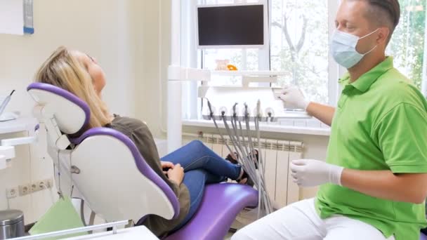 Vidéo 4k du dentiste masculin ajustant la hauteur et l'angle de la chaise des patients avant le traitement des dents — Video