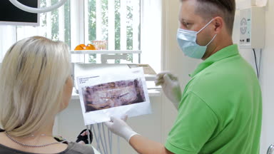 Diş tedavi açıklayan ve x-ray görüntü onun hasta gösterilen diş hekimi 4 k görüntüleri