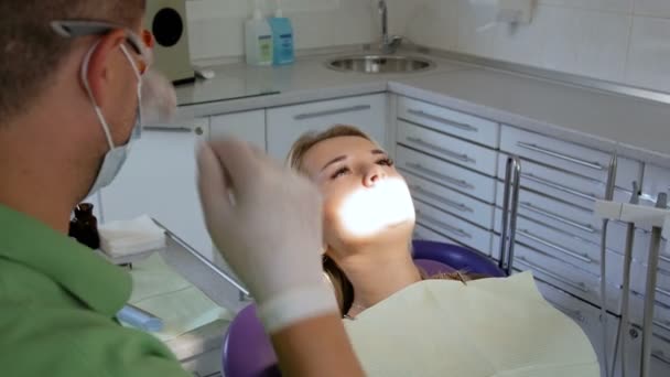 4k відео стоматолога з використанням спеціальної ультрафіолетової лампи для лікування зубів фотополімером — стокове відео
