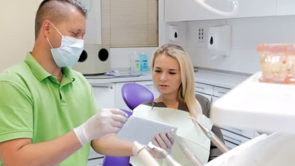 Imagens 4k do dentista explicando o tratamento dos dentes no tablet digital — Vídeo de Stock