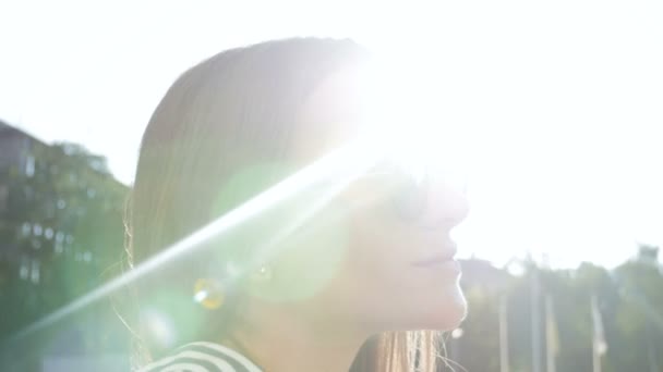 Close up 4k video of beautiful stylish woman looking at sun and taking off sunglasses — стоковое видео