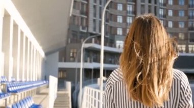 Rüzgarlı gün sokakta yürüme ve kamera seyir uzun saçlı güzel genç kadın ağır çekim görüntüleri