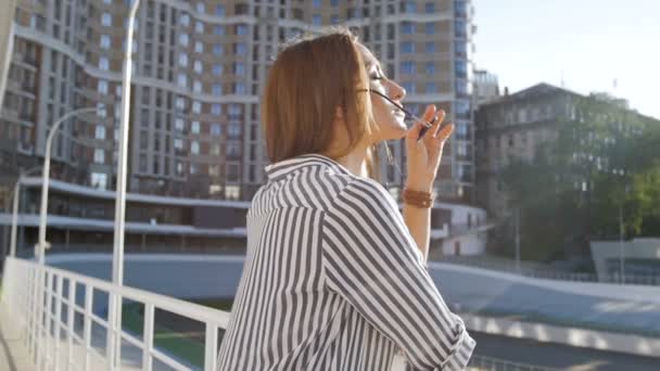 Vidéo au ralenti de belle jeune femme dans la rue au coucher du soleil — Video