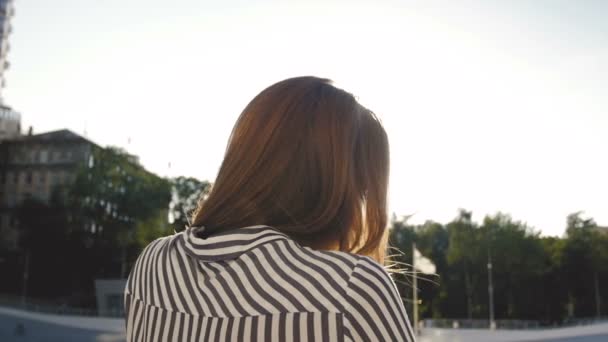 都市の背景にポーズ美しいブルネットの女性の背面ビュー スローモーション映像 — ストック動画