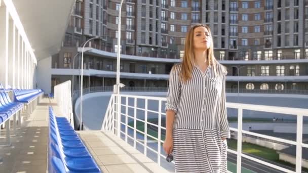 Vidéo au ralenti de jeune belle femme marchant sur un grand stade — Video