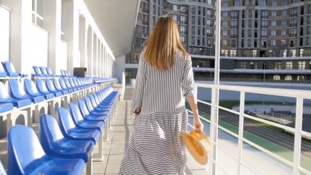 Zpomalené video krásná mladá žena chůze na prázdný stadion tribuny — Stock video