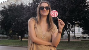 Park büyük lolipop ile poz mutlu gülümseyen kadın Slow motion video