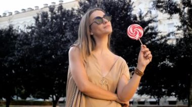 Lolipop konumu Caddesi üzerinde olan genç gülümseyen kadın ağır çekim görüntüleri