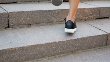 Closeup ağır çekim video siyah spor ayakkabı merdivenlerden yukarı yürümek içinde şık genç kadın