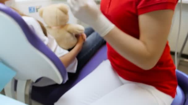 Primer plano 4k video de la mujer edentista tomando instrumentos médicos y la inspección de adolescentes niñas dientes — Vídeos de Stock