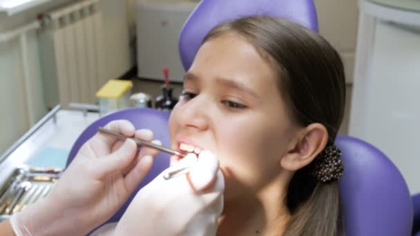 Primer plano 4k metraje del dentista en guantes de látex inspeccionando la boca de las niñas — Vídeo de stock