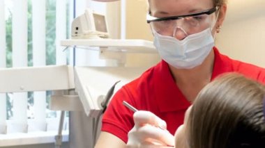 4 k görüntüleri diş sandalyede oturan kadın diş hekimi tedavi genç kızın